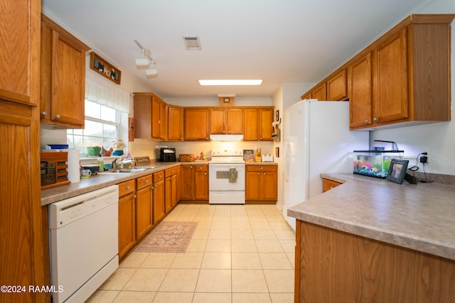 kitchen with light tile patterned floors, white appliances, and sink