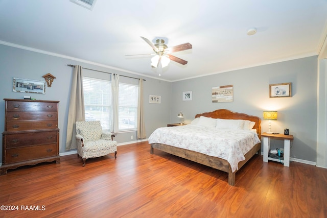 bedroom with ceiling fan, hardwood / wood-style floors, and crown molding