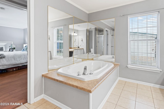 bathroom with a bath, vanity, tile patterned floors, and crown molding