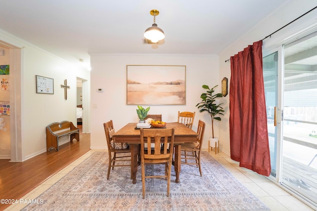 dining room with crown molding and light hardwood / wood-style flooring