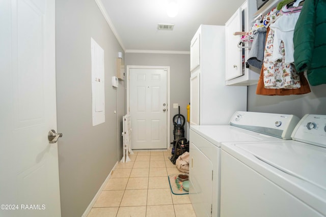 clothes washing area with washer and dryer, cabinets, light tile patterned floors, and ornamental molding