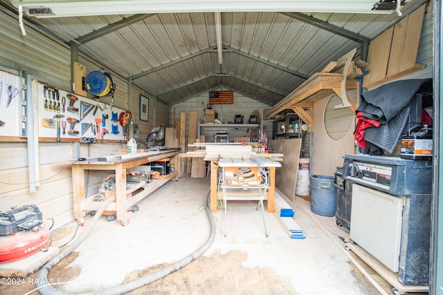 miscellaneous room with a workshop area, wooden walls, and vaulted ceiling