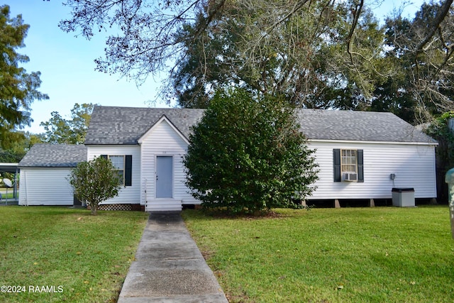 bungalow-style house featuring cooling unit and a front yard