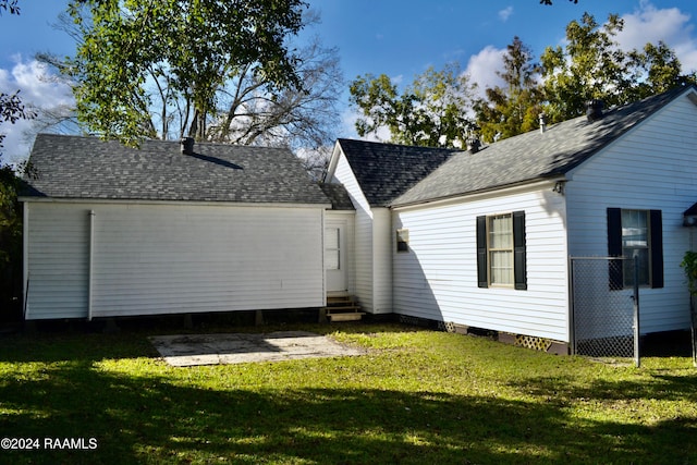 rear view of house featuring a yard