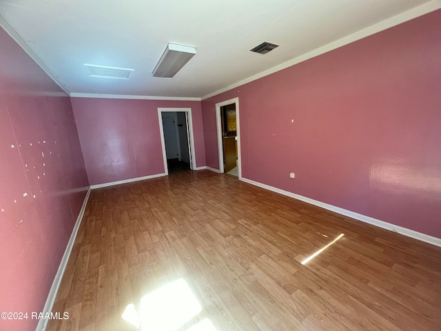 spare room featuring crown molding and hardwood / wood-style flooring