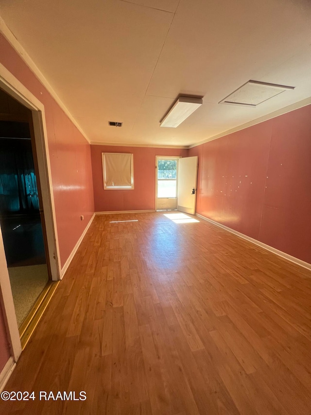 spare room with hardwood / wood-style floors and ornamental molding