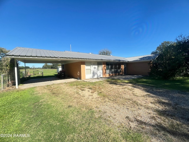 rear view of property with a yard and a carport