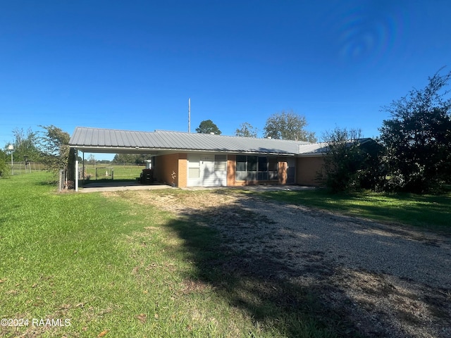 back of property with a yard and a carport