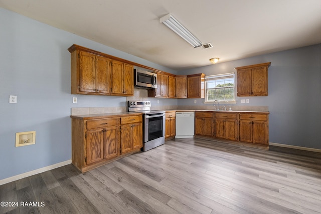 kitchen featuring sink, stainless steel appliances, and light hardwood / wood-style floors