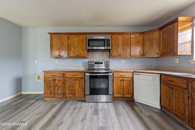 kitchen featuring sink, light wood-type flooring, and stainless steel appliances