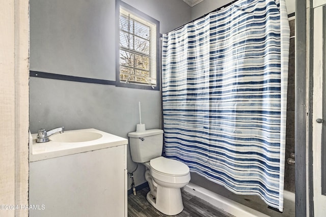 bathroom with wood-type flooring, vanity, toilet, and walk in shower