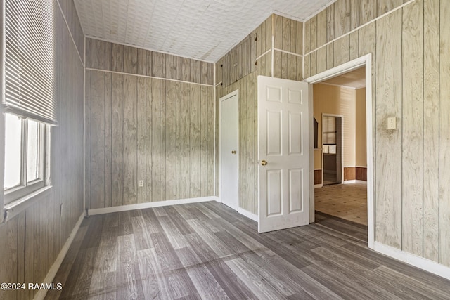 empty room featuring hardwood / wood-style floors and wooden walls