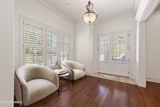 living area with dark hardwood / wood-style flooring, a wealth of natural light, and crown molding