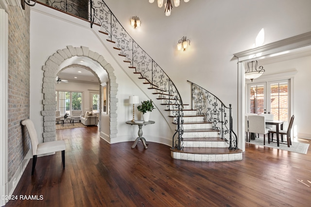 foyer entrance with a high ceiling, a healthy amount of sunlight, and wood-type flooring