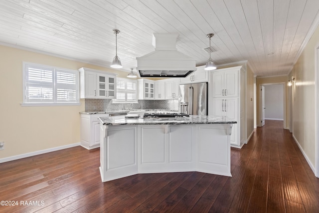 kitchen with high quality fridge, custom exhaust hood, white cabinets, a center island, and dark hardwood / wood-style floors