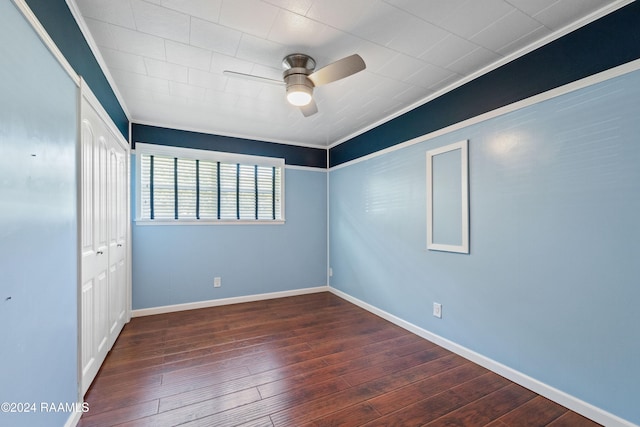 unfurnished bedroom with a closet, ceiling fan, crown molding, and dark wood-type flooring