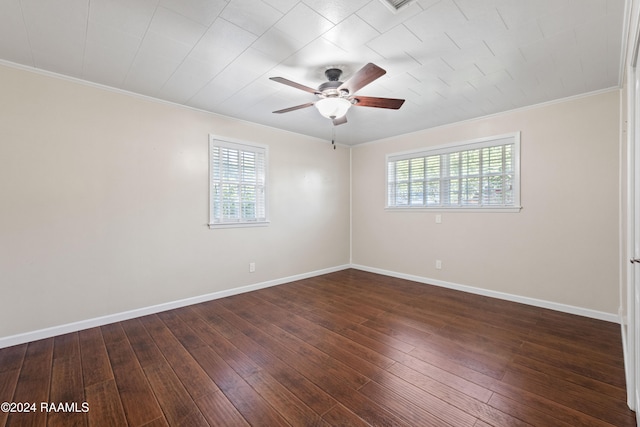 empty room with dark hardwood / wood-style flooring, a wealth of natural light, and crown molding