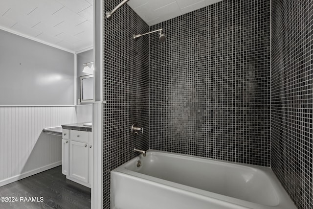 bathroom featuring vanity, hardwood / wood-style flooring, tiled shower / bath combo, and crown molding