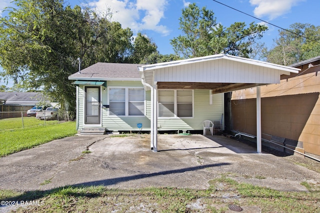 view of front of house with a front lawn and a carport