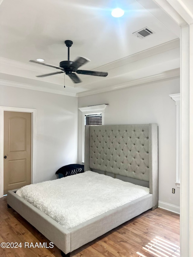 bedroom with hardwood / wood-style floors, ceiling fan, and crown molding