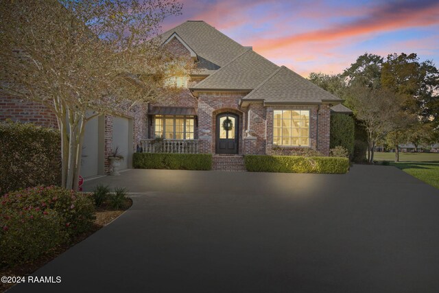 312 Shinnecock Hills Dr, Broussard, LA 70518 - french country style house with brick siding, driveway, a shingled roof, and a garage