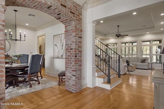 dining room with ceiling fan with notable chandelier, light hardwood / wood-style floors, and ornamental molding