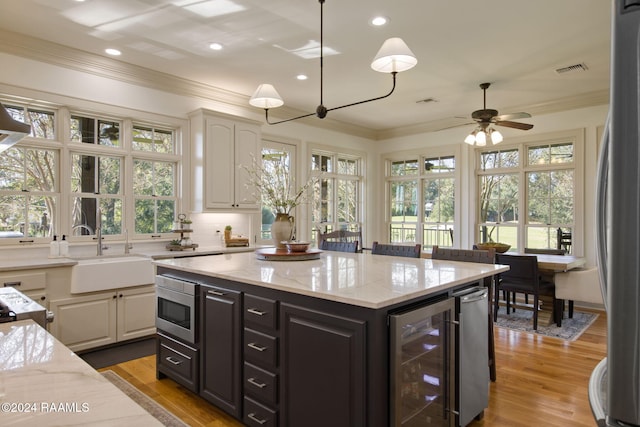 312 Shinnecock Hills Dr, Broussard, LA 70518 - kitchen with wine cooler, a sink, ornamental molding, ceiling fan, and light stone countertops