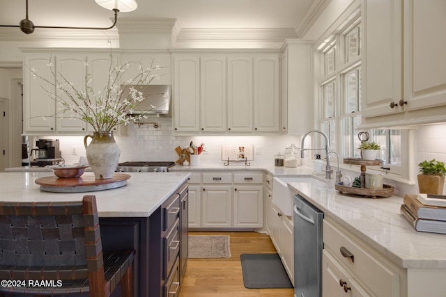 kitchen with light wood-type flooring, backsplash, stainless steel dishwasher, crown molding, and white cabinetry