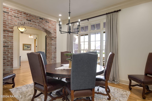 312 Shinnecock Hills Dr, Broussard, LA 70518 - dining area with a chandelier, arched walkways, ornamental molding, baseboards, and light wood-style flooring