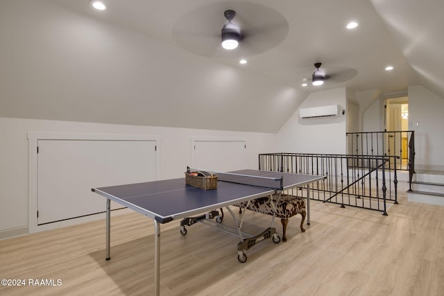 rec room with a wall mounted air conditioner, light hardwood / wood-style flooring, ceiling fan, and lofted ceiling