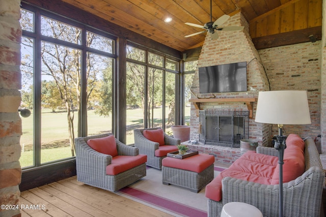 sunroom / solarium with a brick fireplace, vaulted ceiling, ceiling fan, and wooden ceiling