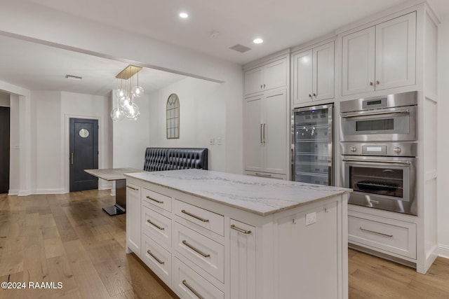 kitchen with a center island, white cabinetry, wine cooler, light hardwood / wood-style floors, and stainless steel double oven