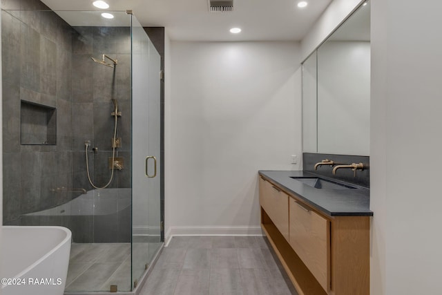 bathroom with vanity and separate shower and tub