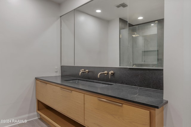 bathroom featuring tasteful backsplash, tile patterned floors, vanity, and a shower