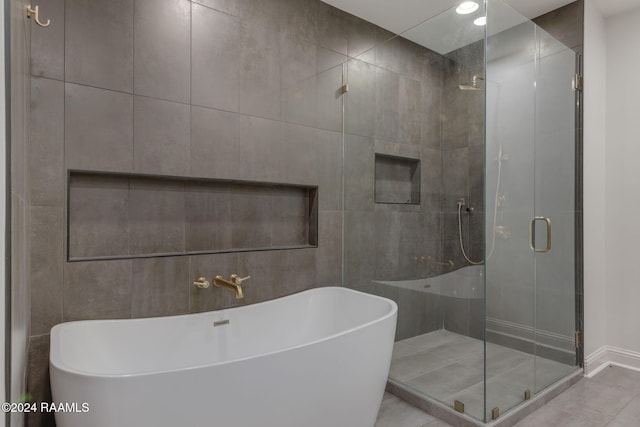 bathroom featuring shower with separate bathtub and tile walls