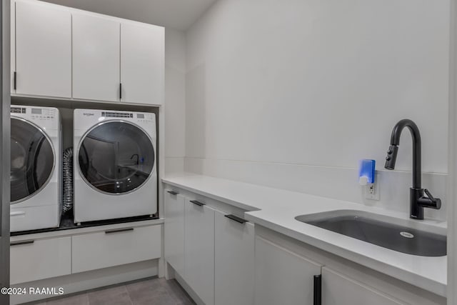 washroom with washer and dryer, light tile patterned flooring, cabinets, and sink