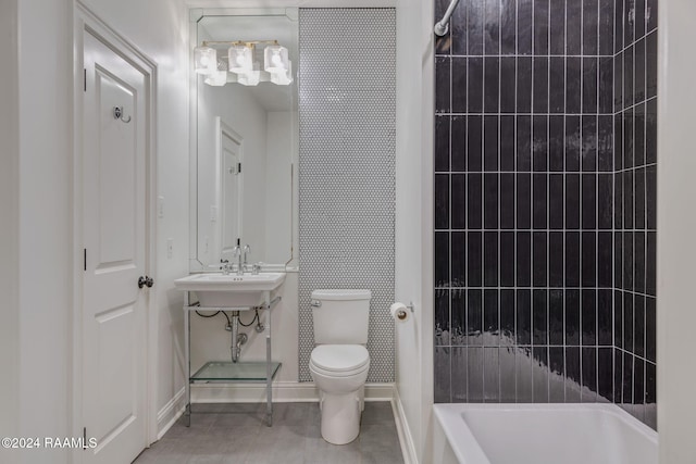 bathroom with tile patterned floors, a washtub, and toilet