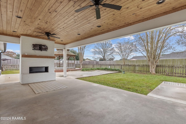 view of patio with an outdoor brick fireplace and ceiling fan