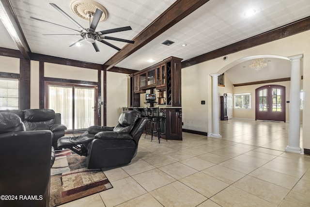 living room with plenty of natural light, light tile patterned floors, and ceiling fan with notable chandelier