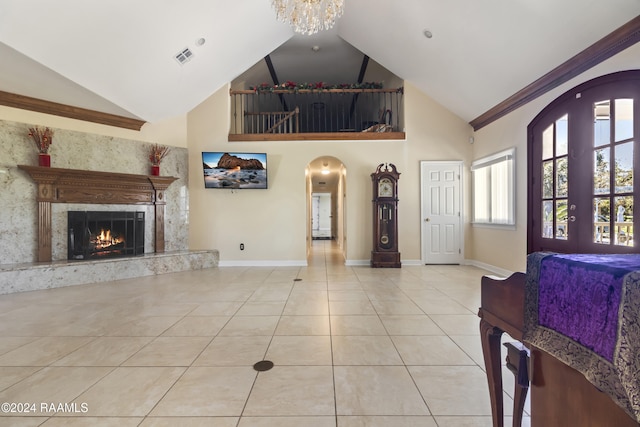 tiled living room featuring a fireplace, high vaulted ceiling, and a chandelier