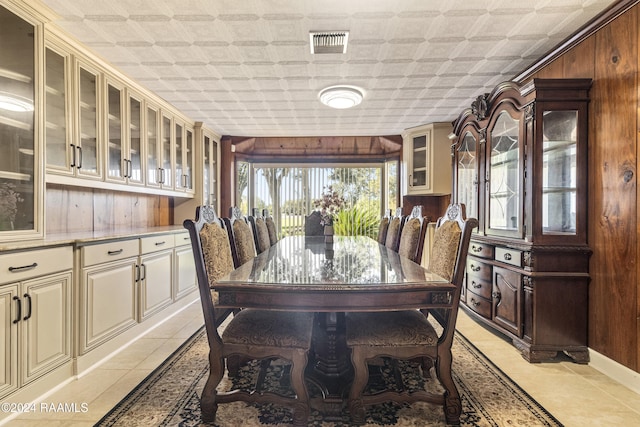 1412 US Highway 167, Abbeville, LA 70510 - dining room with light tile patterned floors, an ornate ceiling, and wooden walls