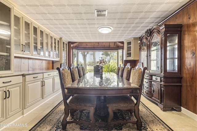 tiled dining space featuring wooden walls