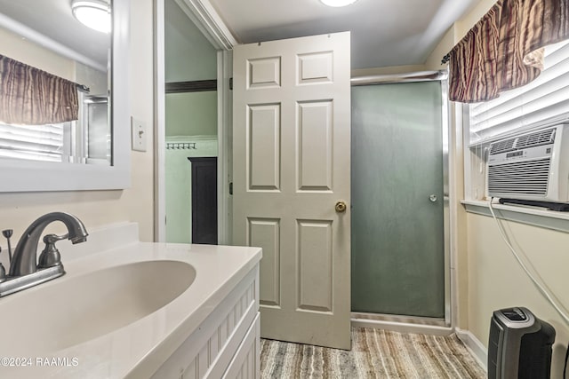 bathroom featuring cooling unit, hardwood / wood-style floors, vanity, and walk in shower