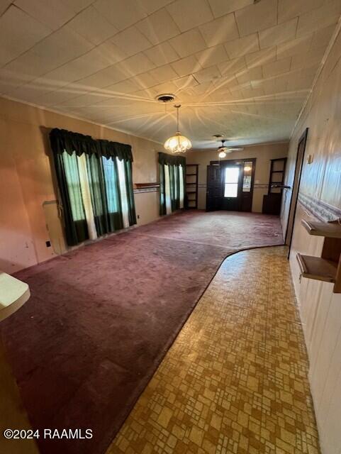 unfurnished living room with ceiling fan and carpet