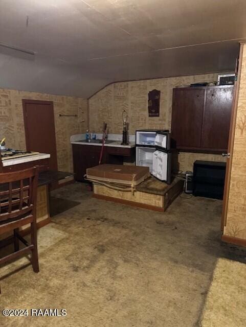 kitchen with lofted ceiling and carpet floors