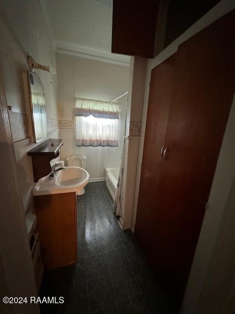 bathroom with tile patterned flooring, vanity, and a healthy amount of sunlight