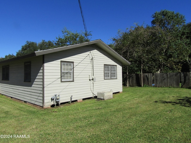 view of side of home featuring central air condition unit and a lawn