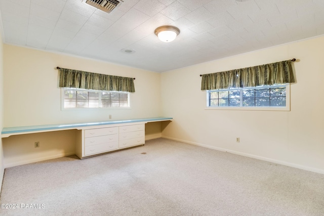 unfurnished office featuring light carpet and built in desk