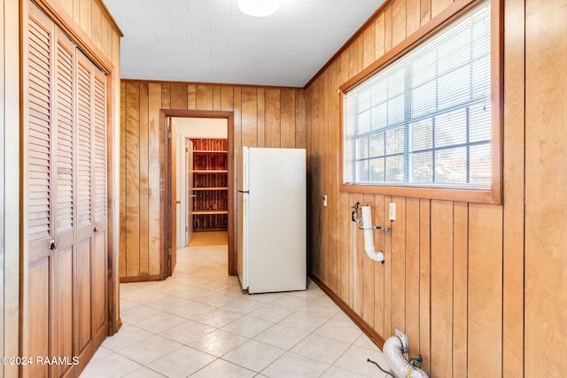 interior space with light tile patterned floors and wood walls