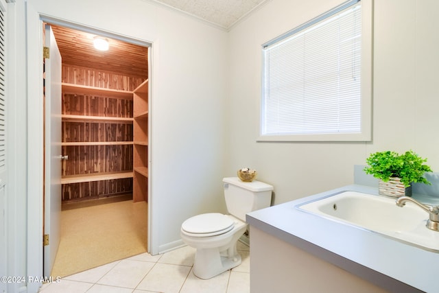 bathroom with vanity, crown molding, tile patterned flooring, toilet, and a textured ceiling